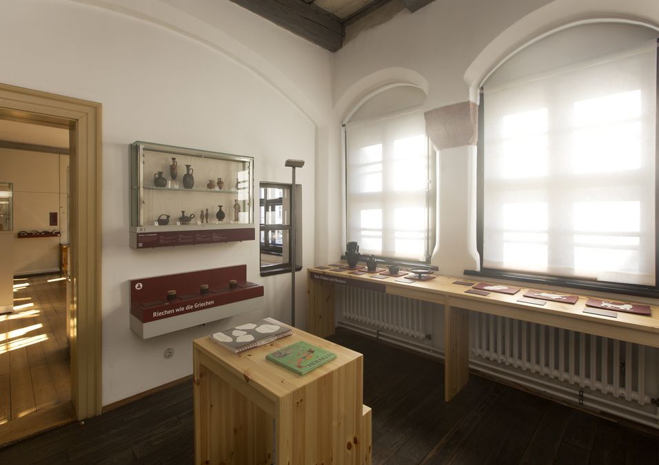 zur Vergrößerungsansicht des Bildes: Das Kabinett mit einem Teil unserer barrierefreien Angebote. Der Raum weist noch eine originale Holzbalkendecke aus dem 16. Jahrhundert auf.