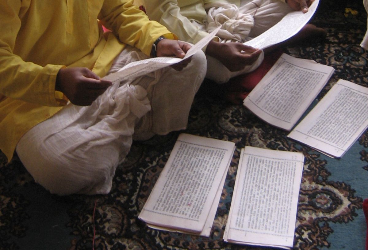 zur Vergrößerungsansicht des Bildes: Zwei Männer sitzen beim studieren von Manuskripten auf dem Boden, Indien, 2008, Foto: Johanna Buß