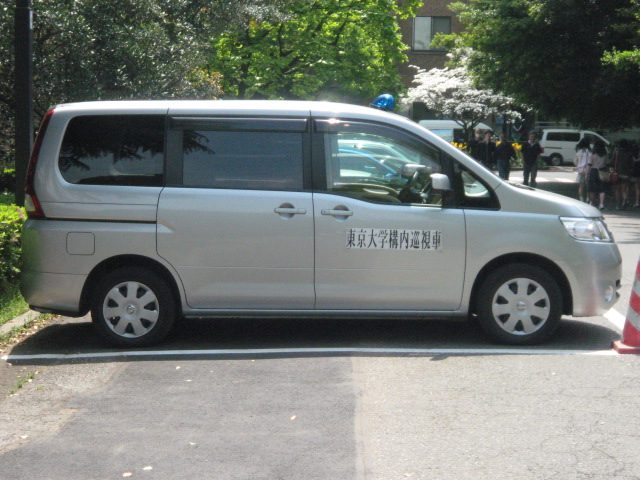 Ein Fahrzeug versperrt den Weg. Es handelt sich um einen "Streifenwagen der Universität Tokio". 
