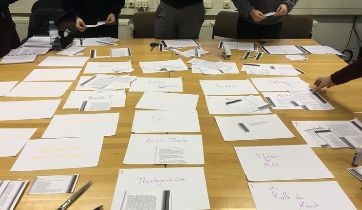 Tische mit ausgeschnittenen Textfragmenten und Notizen zum Projekt "Messingkauf"