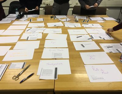 Tische mit ausgeschnittenen Textfragmenten und Notizen zum Projekt "Messingkauf"