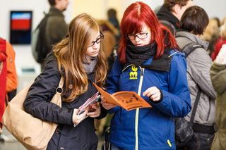 Zwei Studieninteressentinnen schauen in ein Informationsheft auf dem Studieninformationstag der Universität Leipzig; 2014, Foto: Christian Hüller