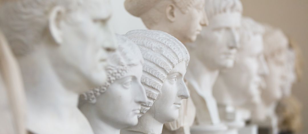 Gipsabgüsse antiker Skulpturen, darunter männliche und weibliche Köpfe mit ausgeprägten Frisuren, allesamt in weißem oder hellen Gips