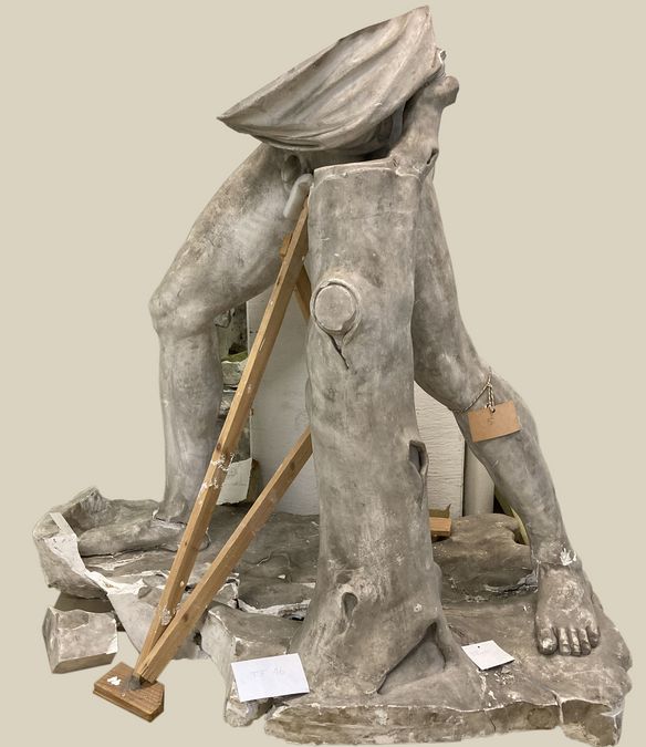 Gipsabguss des Toro Farnese, Abgusssammlung Universität Leipzig, Beine und unterer Bauch einer männlichen Figur im Ausfallschritt, zudem Stütze in Form eines Baumes und Bodenplatte der Figur