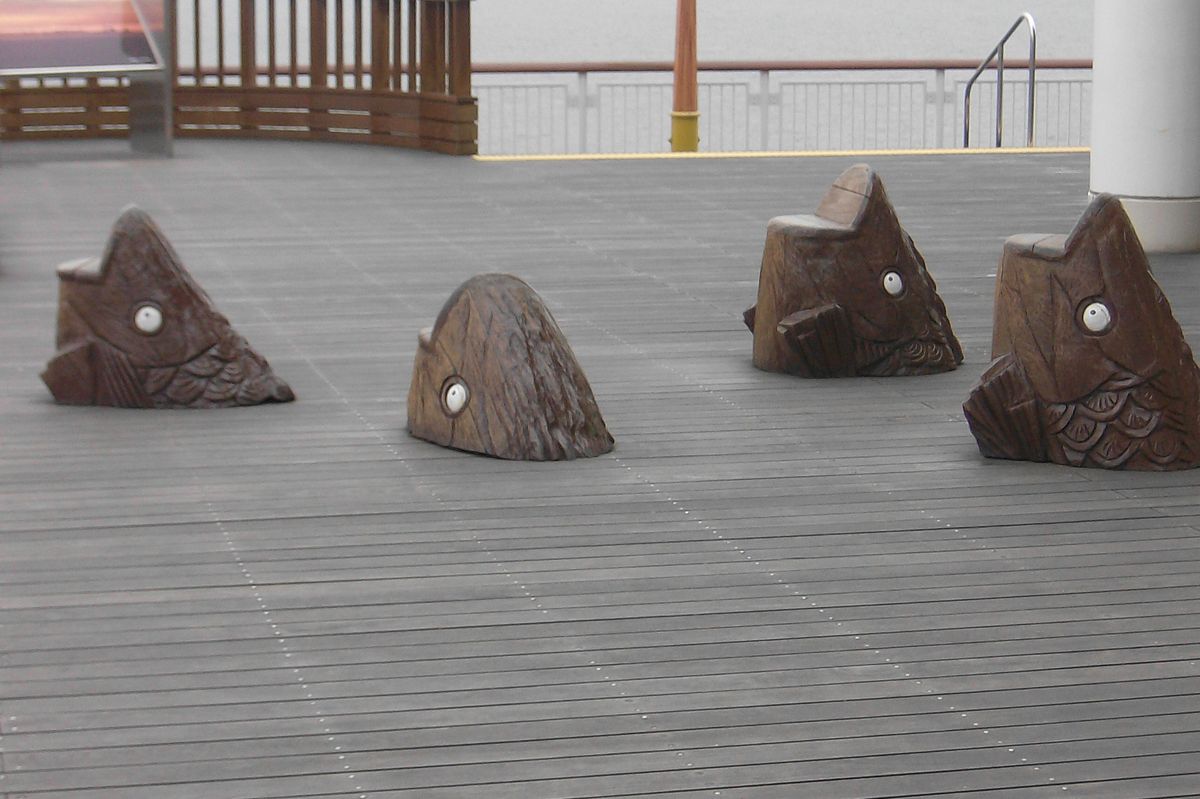 zur Vergrößerungsansicht des Bildes: Kunst im öffentlichen Raum: Skulpturen aus dem Boden ragender Fische, die nach Luft schnappen. Wir befinden uns auf dem Umihotaru Observation Deck der Tōkyō-wan Aqua Line.