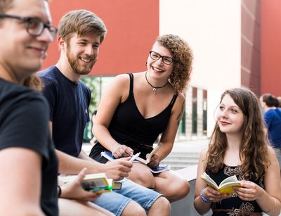 Studentinnen und Studenten unterhalten sich auf dem Campus Augustusplatz