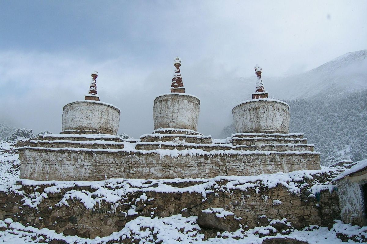 Gruppe von drei verschneiten Stupas in einer felsigen Gebirgslandschaft in Reting, Tibet, 2006 , Foto: Berthe Jansen 