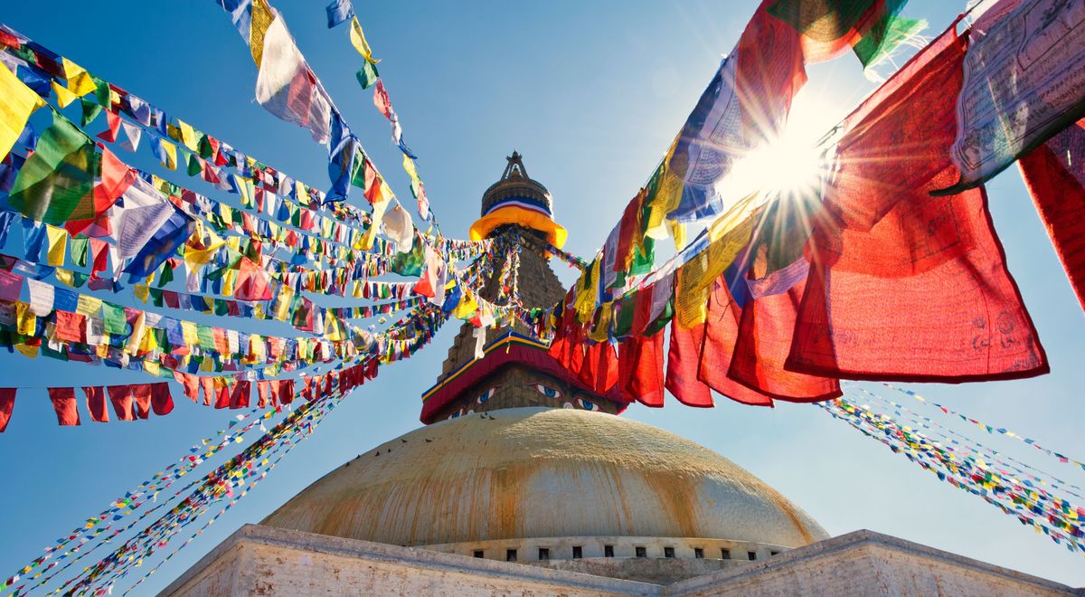 Im Zentrum des Bildes ist der Boudhanath Stupa in Nepal zu sehen. Darum hängen viele tibetische Gebetsfahnen., © Adobe Stock, Foto: Emanuel