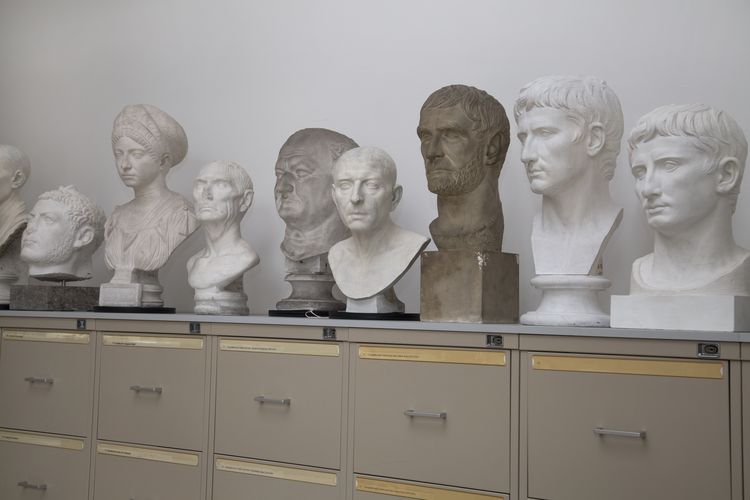 Eine Reihe von Gipsabgüssen antiker Skulpturen, welche aufgereiht auf Aufbewahrungskästen für Fotos im Studiensaal der Ritterstraße 14 stehen, Foto: Marion Wenzel