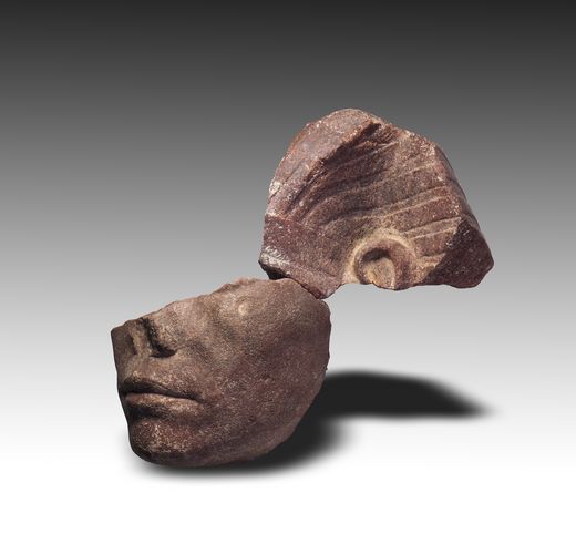 Kopffragment einer Königsstatue aus Stein mit Teil des Königskopftuchs