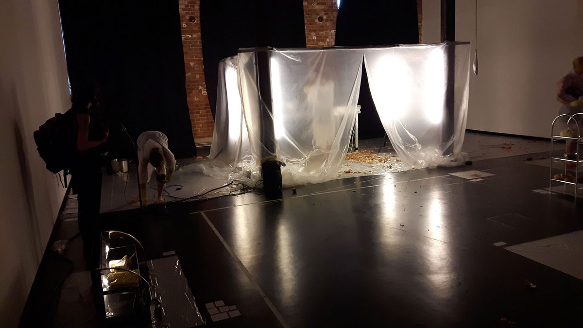 zur Vergrößerungsansicht des Bildes: Aufführung auf der Probebühne; in der Mitte ein beleuchteter Kubus aus Plastikfolie