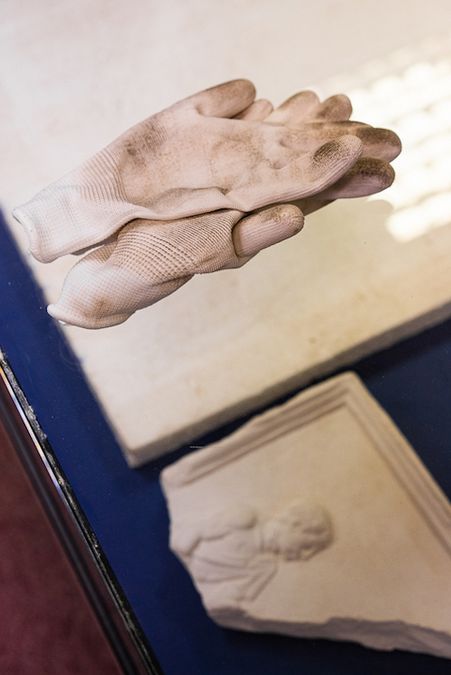 zur Vergrößerungsansicht des Bildes: Restaurationshandschuhe liegen auf einer Glasvitrine mit Gipsabgüssen antiker Kleinkunst in der Gipsabguss-Sammlung