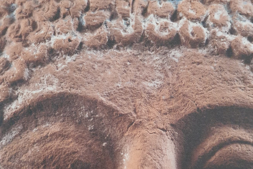 Nahaufnahme des Gesichtes einer archaischen Statuette mit Rückständen vergangener Bemalung, Foto: Antikenmuseum