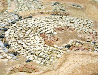 Kleine Mosaiksteine in hellen Farben sind regelmäßig und kreisförmig angeordnet