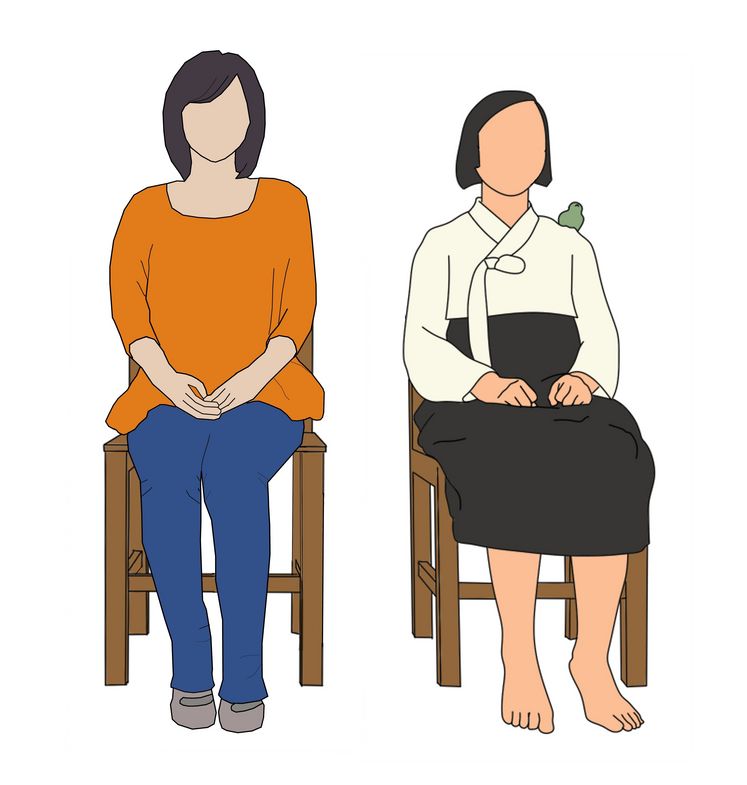 Das Bild zeigt die sitzende Friedensstatue. Neben ihr sitzt eine weibliche Person, die die Hände im Schoß gefaltet hat und gedankenversunken nach vorne schaut.
