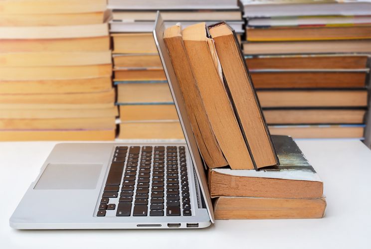 Bücher, die an einem Laptop lehnen