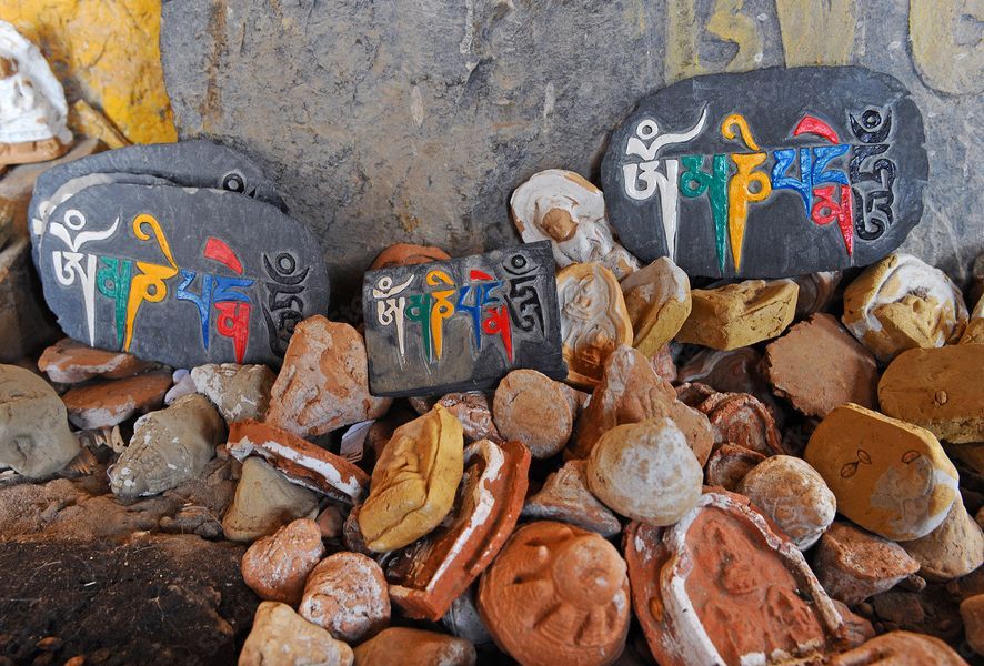 Das Bild zeigt religiöse Mani-Steine in Tibet (Übersetzung des auf den Steinen geschriebenen Textes "om mani padme hum": "Gegrüßt sei der Buddha im Lotos")
