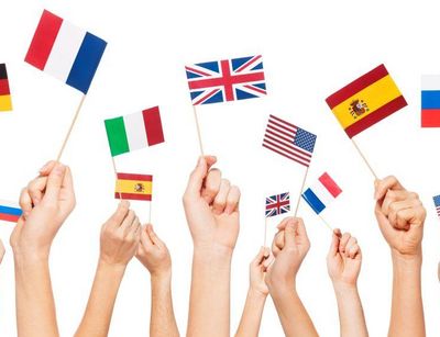 viele Hände halten Fähnchen verschiedener Länder in die Höhe, Quelle: Colourbox