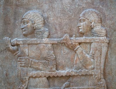 Section of a Neo Assyrian relief showing two servants carrying a table. Photo: Colourbox