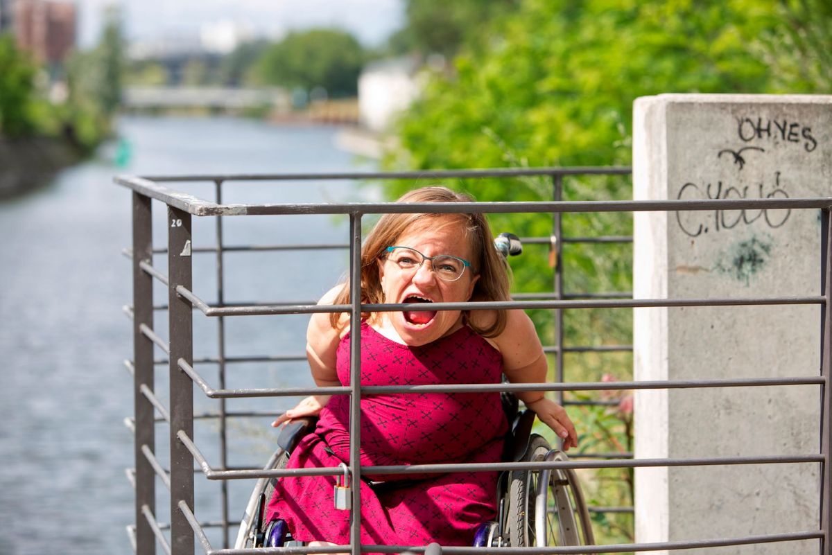 Die Performerin Jana Zöll, schreiend, auf einer Brücke am Fluss, Foto: Gianni Plescia
