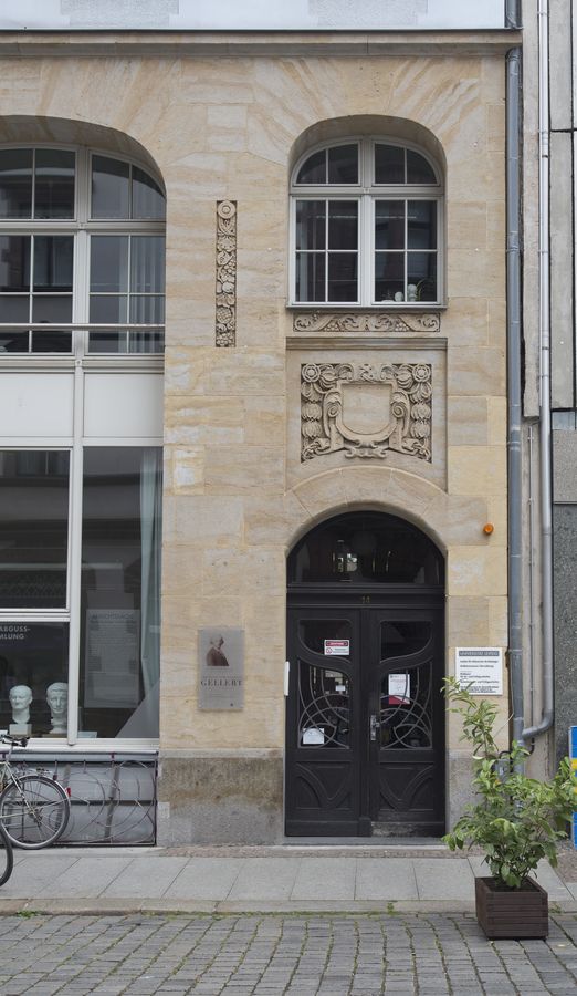 zur Vergrößerungsansicht des Bildes: Eingang in das Institutsgebäude in der Ritterstraße 14, links Blick in den Studiensaal mit Gipsabgüssen auf der Fensterbank, rechts eine Pflanze, die zur Begrenzung der Sitzgelegenheiten des benachbarten Kiosk dient